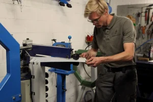 Artesao-automotivo-trabalhando-manualmente-na-restauracao-de-carro-classico-reforcando-habilidade-e-cuidado-no-processo