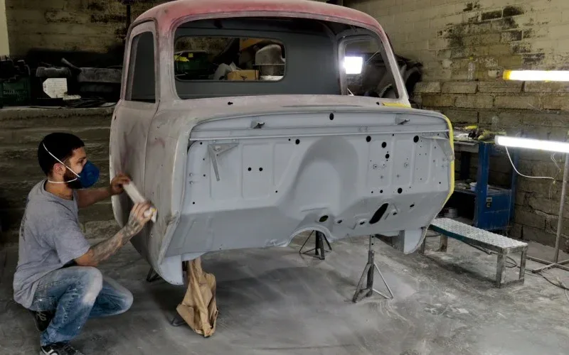 Profissional-trabalhando-na-restauracao-artesanal-de-carro-classico-em-oficina-especializada