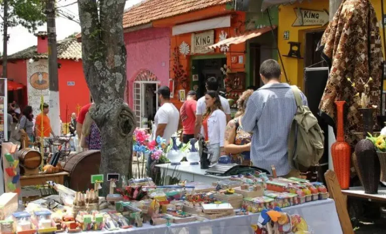 Turistas-explorando-uma-feira-de-artesanato-local-durante-evento-cultural-interagindo-com-artesaos-e-produtos-tipicos-da-regiao.