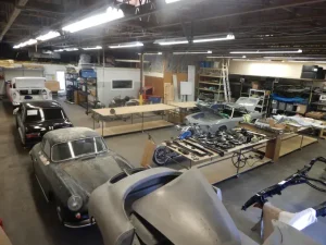 Oficina-de-restauracao-automotiva-com-varios-carros-classicos-em-diferentes-estagios-de-funilaria-e-restauracao-artesanal.